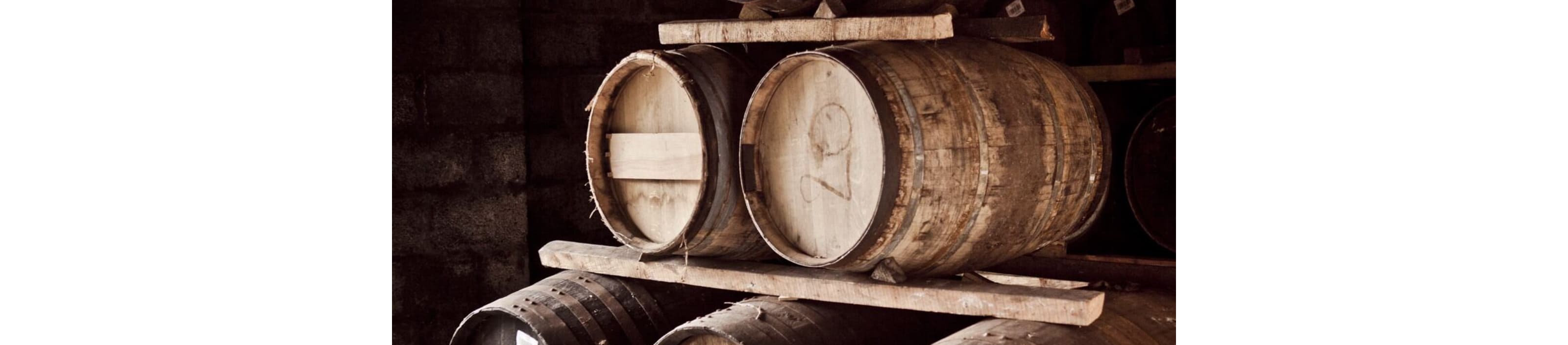 Casks of whisky in a traditional warehouse.